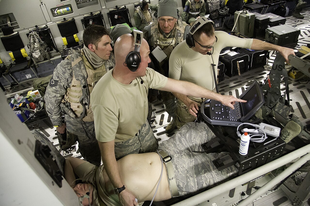 Medical personnel use an ultrasound machine during an emergency-medicine training exercise aboard a military aircraft.